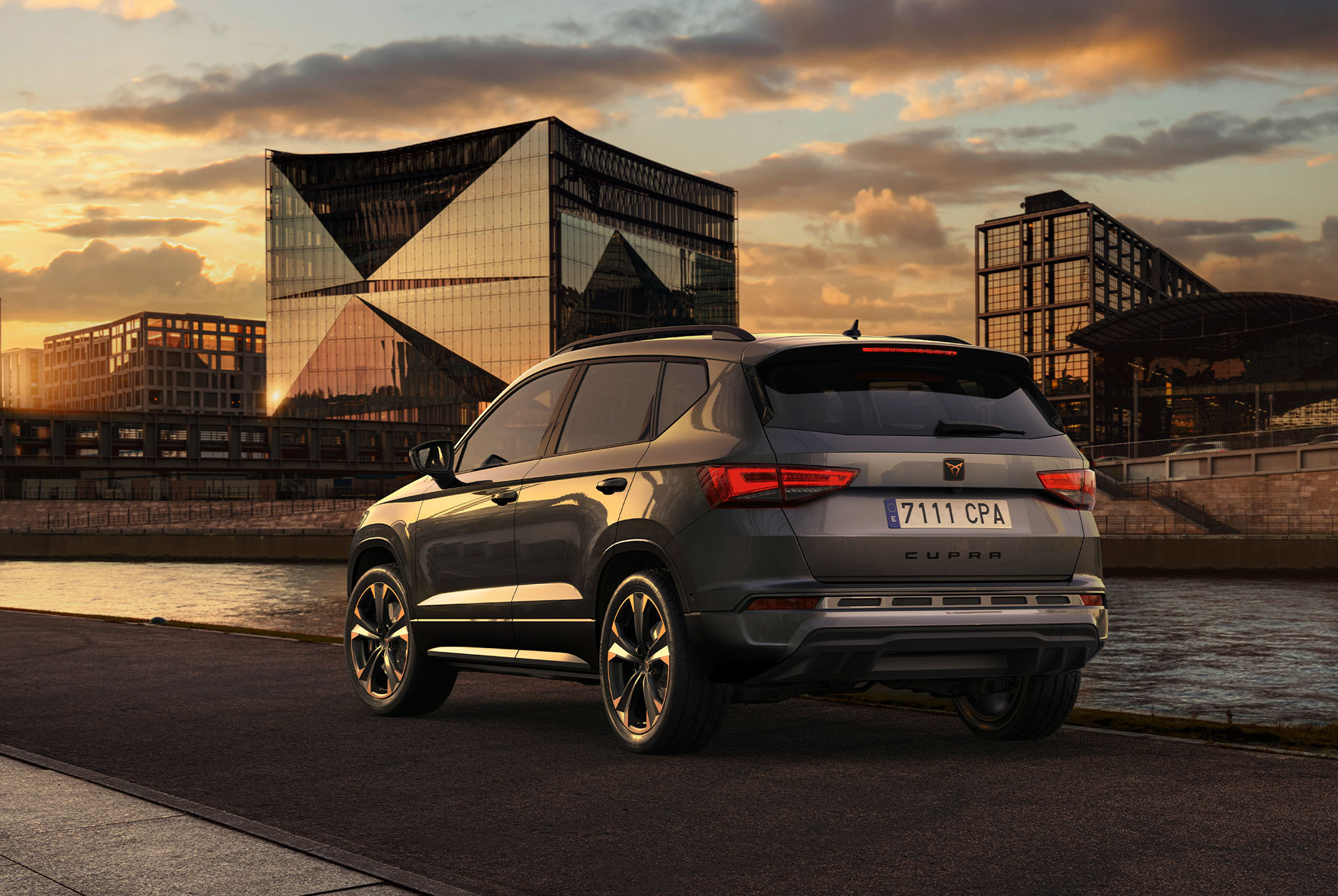 Vue arrière du SUV CUPRA Ateca au coucher du soleil, mettant en évidence la nouvelle calandre inférieure avec caches d'air et le nouveau diffuseur arrière, tous deux conçus pour renforcer le design extérieur et prendre soin de l'aérodynamique.