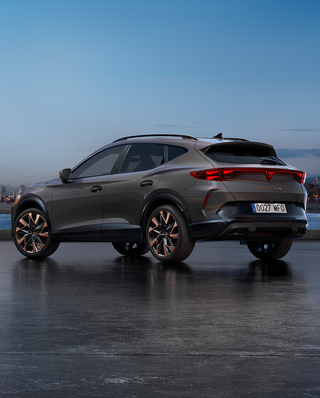 Un nouveau CUV CUPRA Formentor 2024 Graphene Grey garé sur une promenade au bord de l'eau au crépuscule. L'arrière-plan représente un paysage urbain avec des gratte-ciel et des palmiers illuminés par la lumière déclinante du jour.