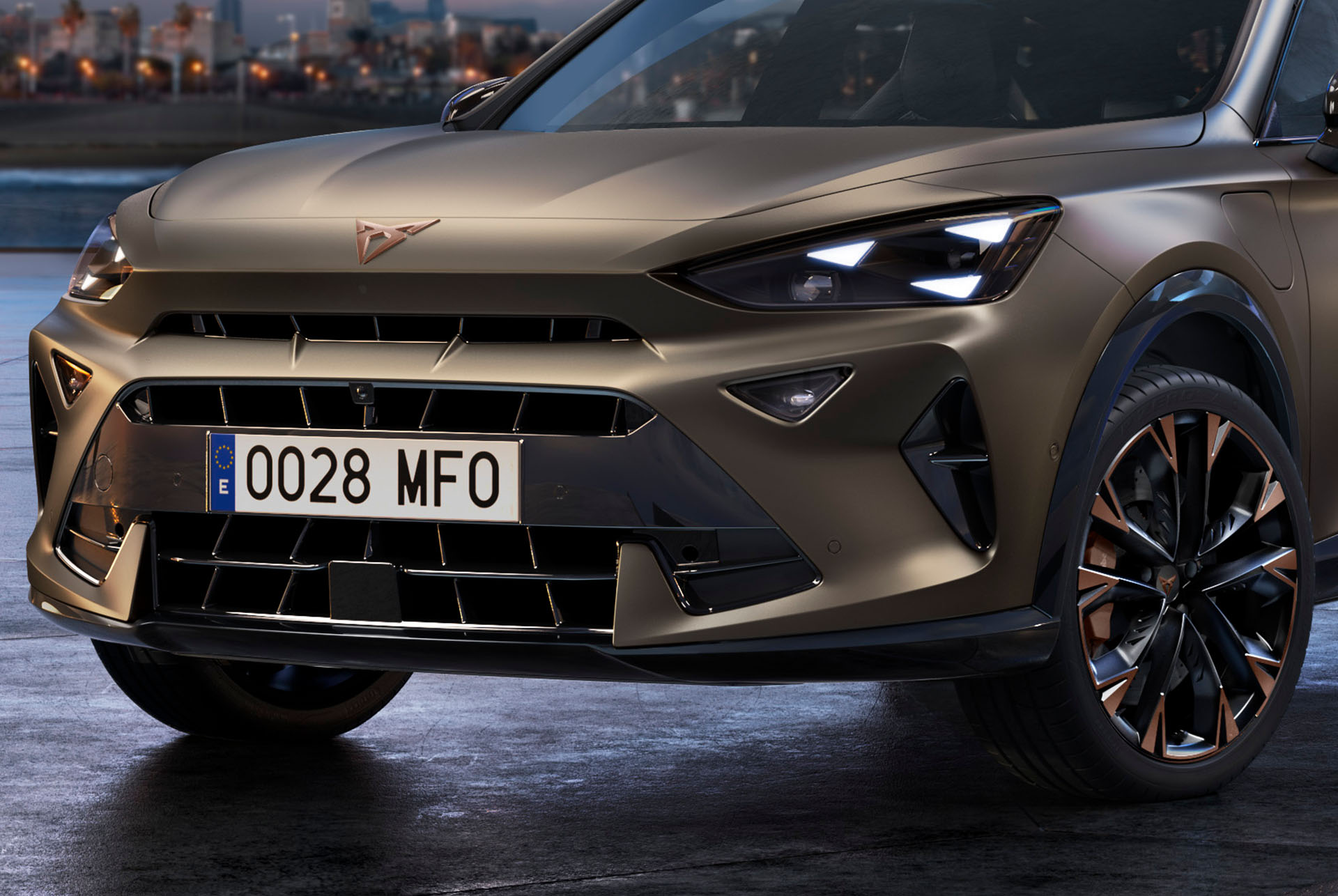 Gros plan sur l'avant d'un nouveau CUPRA Formentor 2024 de couleur bronze avec des jantes aux accents cuivrés, des feux avant en forme d'œil de triangle et le logo CUPRA distinctif.r accent wheels, signature triangle eye front lights and distinctive CUPRA logo.