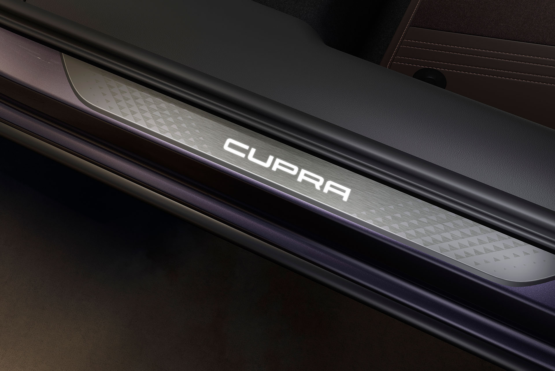 Equipment upgrade edge close up of interior illuminated scuff plates inside cupra terramar vz in dark void colour.