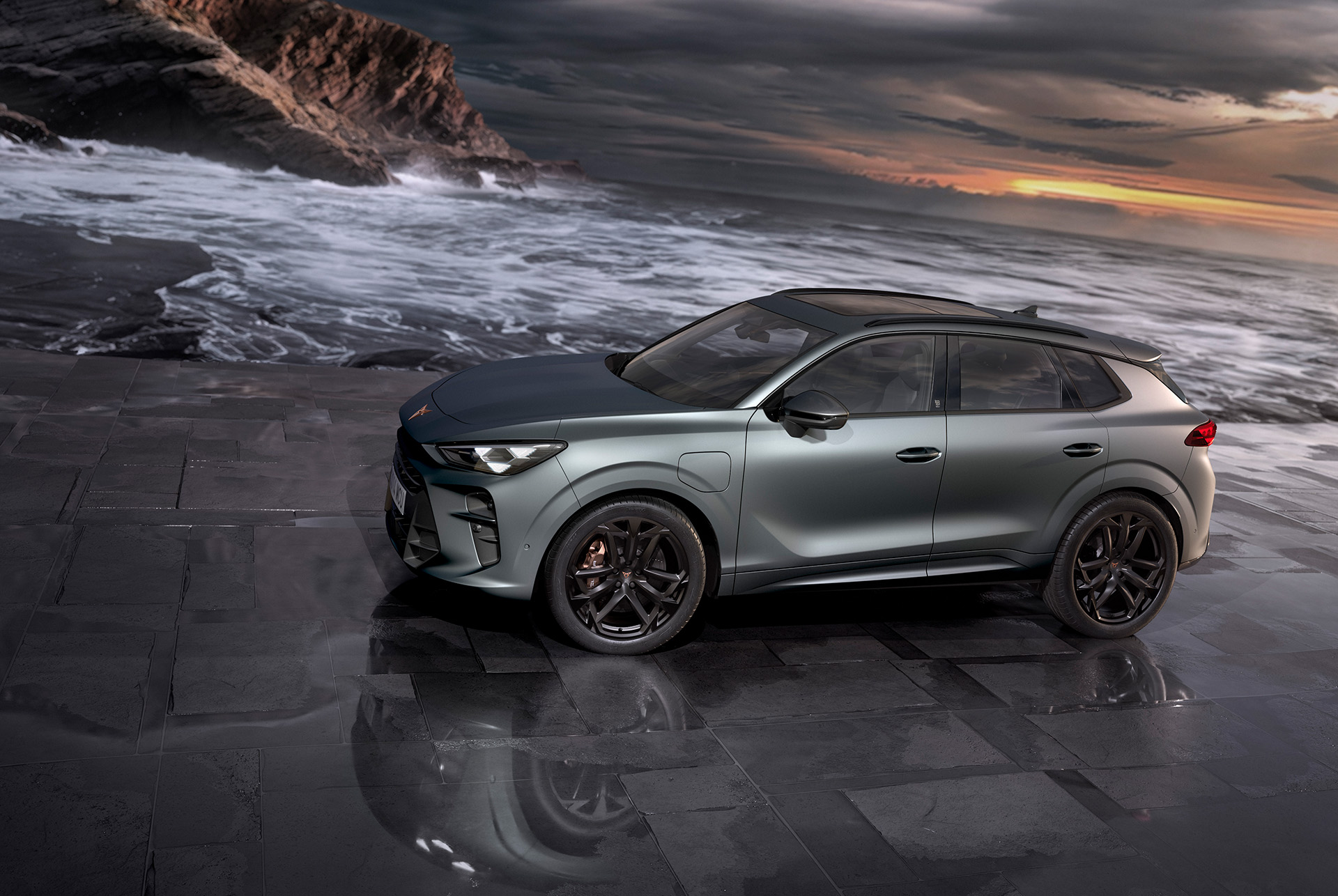 Cupra terramar hybrid suv, nouveau modèle 2024, vue latérale, avec jantes en alliage america's cup de 20 pouces et freins akebono, gris encelade mat, sur une chaussée humide au bord de la mer au coucher du soleil.