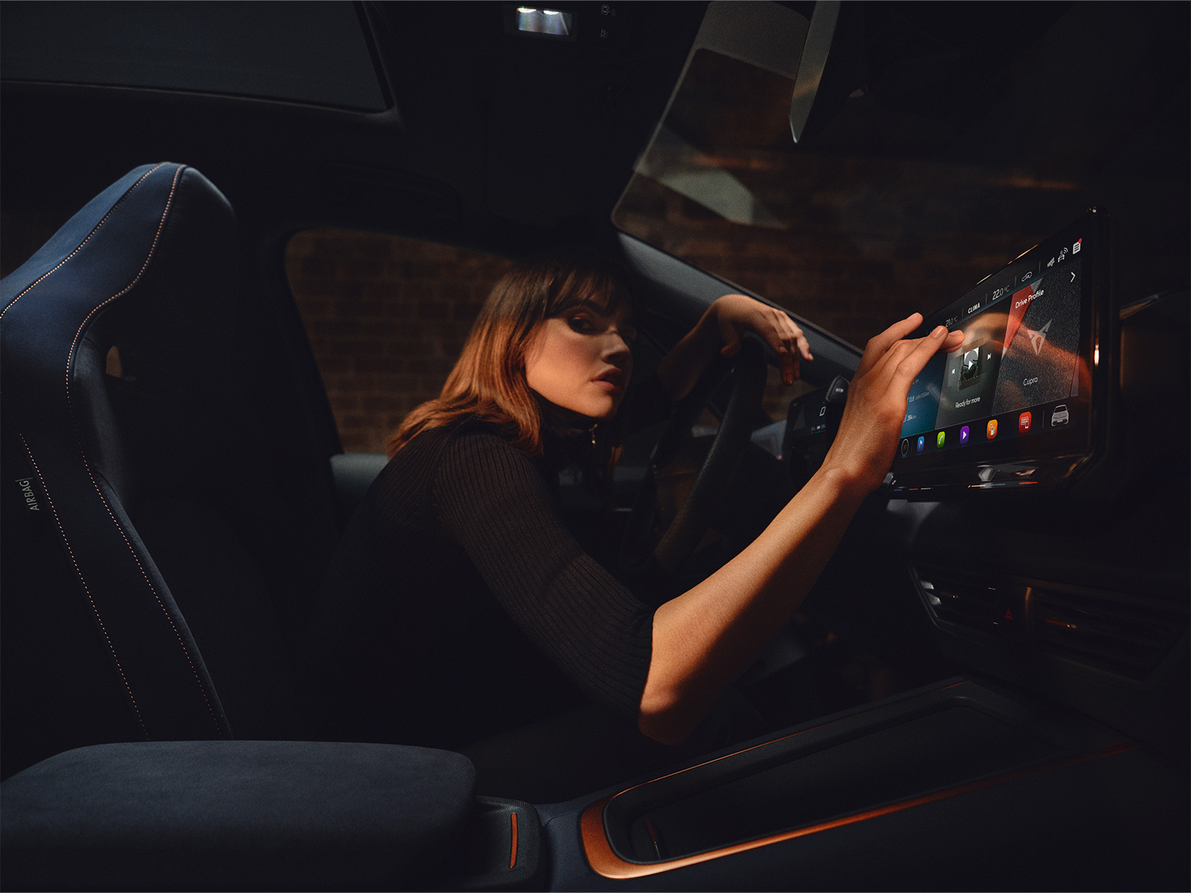 une femme utilise le système d'infodivertissement de la voiture pour vérifier les mises à jour et s'assurer qu'elle dispose du dernier logiciel CUPRA.